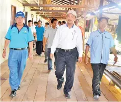  ??  ?? Maximus (left) and Ruji Ubi (middle) inspecting the newly-repaired longhouse at Kampung Hobut yesterday.