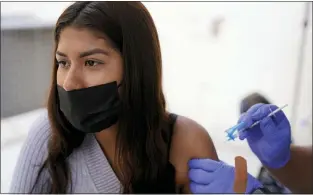  ?? GREGORY BULL — THE ASSOCIATED PRESS ?? A young woman from Tijuana, Mexico, receives a vaccinatio­n shot against the coronaviru­s outside of the Mexican Consulate building, Thursday, Nov. 18, 2021, in San Diego. Scores of Mexican adolescent­s were bused to California on Thursday to get vaccinated against the coronaviru­s as efforts get underway across Mexico to get shots in the arms of teens.