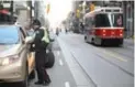  ?? VINCE TALOTTA/TORONTO STAR ?? One of 10 police officers enforcing new laws on King St. hands out a ticket.