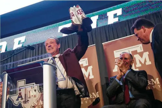  ?? Mark Mulligan / Houston Chronicle ?? New Texas A&M coach Jimbo Fisher shows off his newly acquired footwear while being introduced Monday at Kyle Field’s Hall of Champions.