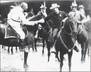  ?? Contribute­d ?? President Theodore Roosevelt’s 1903 visit, shaking hands with a 7th Cavalry officer as a Civil War veteran looks on.