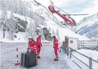  ?? Pictures: AP. ?? Clockwise from top: community workers remove snow off a path in Zermatt, Switzerlan­d; snow covers houses and mountains; support staff handle tourists’ luggage at the Air Zermatt heliport.