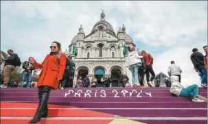  ?? GEOFFROY VAN DER HASSELT / AFP ?? Left: Visitors gather at stairs painted in the colors of the upcoming Paris Olympics in front of the city’s Sacre Coeur Basilica on top of Montmartre hill on Wednesday.
