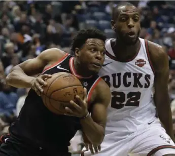  ?? MORRY GASH/THE ASSOCIATED PRESS ?? Raptor Kyle Lowry, playing without wraps on his hands after battling sore fingers in recent games, drives past Khris Middleton of the Bucks in Friiday night’s game in Milwaukee. Lowry scored 15 points, adding six rebounds.