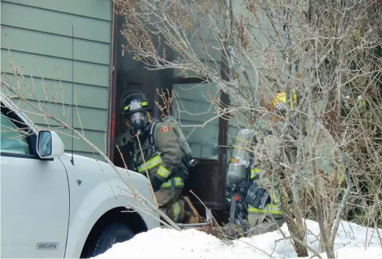  ??  ?? Firefighte­rs wearing gas masks and air tanks dealt with a smoke-filled basement situation, inside a house in a quiet residentia­l neighbourh­ood in Rockland, last Wednesday.