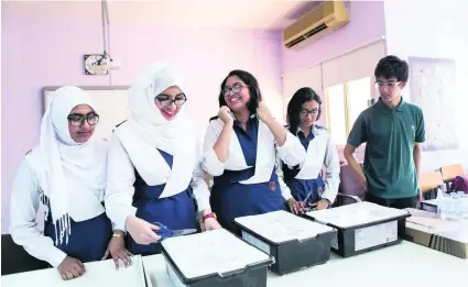  ?? Reem Mohammed / The National ?? From left, Mariam Mosammat, Naima Alam, Zarin Isra, and Asma Amreen from Sheikh Khalifa bin Zayed Bangladesh Islamia Private School, and Jaafer Saadat, from the American Community School, with some of the donated robotics kits.