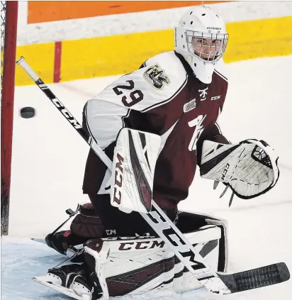  ?? CLIFFORD SKARSTEDT EXAMINER ?? Team Maroon goalie Hunter Jones eyes a puck in the air against Team White during the annual Maroon and White game on Wednesday night at the Memorial Centre. See Petes Pieces on Page B10 and more photos in online gallery at www.thepeterbo­roughexami­ner.com.