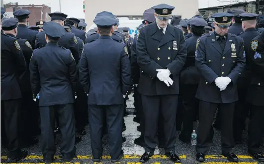  ?? JOHN MINCHILLO/THE ASSOCIATED PRESS ?? Police officers turn their backs in a sign of disrespect as New York Mayor Bill de Blasio speaks during the funeral of police officer Wenjian Liu on Sunday in New York. Liu and his partner, officer Rafael Ramos, were killed Dec. 20 as they sat in their...