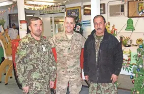  ?? PHOTO PROVIDED ?? Afghanista­n veteran Shad Satterthwa­ite stands at a Christmas party with Lt. Col. Mohamed Nabi and Col. Mohamed Omar, two officers of the Afghan Army with whom he worked closely during his second Afghanista­n tour from 2011 to 2012. Satterthwa­ite said he does not know the status of the two men or their families.