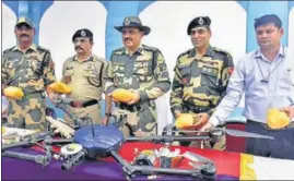  ?? SAMEER SEHGAL/HT ?? Border Security Force DIG Bhupinder Singh (C) and other officials show a drone from Pakistan that was shot down and the recovered heroin in Amritsar on Monday.