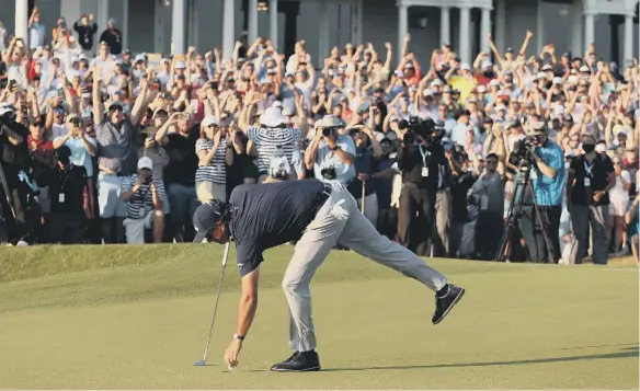  ??  ?? Phil Mickelson of the United States retrieves his golf ball on the 18th green after putting to win the 2021 PGA Championsh­ip held at the Ocean Course.