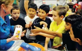  ?? Buy this photo at YumaSun.com FILE PHOTO BY RANDY HOEFT/YUMA SUN ?? ALICE BYRNE ELEMENTARY SCHOOL SECOND-GRADE TEACHER Kate Hazen (left) distribute­s the ingredient­s for baking a cake, including flour, sugar, butter and eggs, to students in her class. The students were baking cakes from scratch after reading the book, “Hedgehog Bakes a Cake,” by Maryann Macdonald. A new report by the Arizona School Personnel Administra­tors Associatio­n found that the 178 school districts and charter schools that responded to the survey reported they needed to fill 6,227 slots this school year.