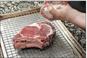  ??  ?? Before cooking, place the steak on a rack over a baking sheet and season liberally. Allow it to rest an hour in the refrigerat­or, if you have time.