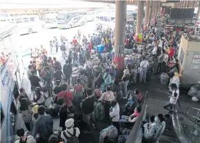  ?? NUTTHAWAT WICHEANBUT ?? People wait to board buses at Mor Chit bus terminal in Bangkok last Sunday after the closure of 26 types of business in Greater Bangkok to tackle the spread of Covid-19.