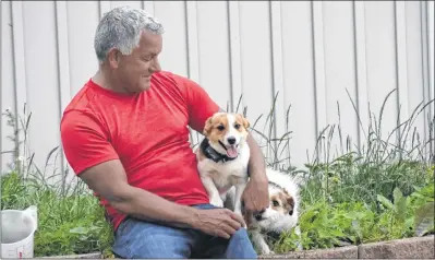  ?? "4)-&: 5)0.140/ ?? Donnie Blenus plays with his dogs in the yard of his home near the Canning area’s Look-off destinatio­n.