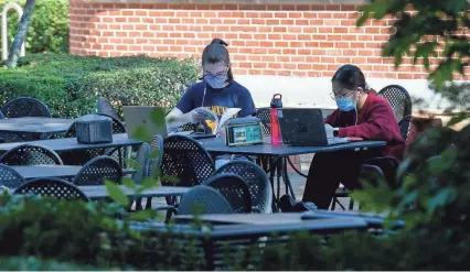  ?? PHOTOS BY MAX GERSH / THE COMMERCIAL APPEAL ?? Freshmen Virginia Hensley (left), 18, and Krystel Matutino, 17, study in a courtyard after an architectu­re class on Aug. 24 on the University of Memphis campus. While Hensley, who is from Memphis, and Matutino, who is from Bartlett, are completing mostly online courses, the two find it easier to study and focus out being out of the house. “This might be the most campus experience we have this semester,” Matutino said.