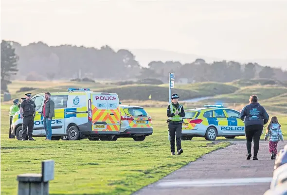  ?? Picture: Steve Macdougall. ?? Police officers and vehicles parked near the scene where the body on the beach at Carnoustie was found yesterday.