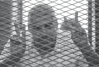  ?? KHALED DESOUKI/ AFP/GETTY IMAGES ?? Al-Jazeera news channel’s Egyptian-Canadian Mohamed Fadel Fahmy listens inside the defendants’ cage to the verdict at his trial for allegedly supporting the Muslim Brotherhoo­d. He was sentenced to seven years in jail.