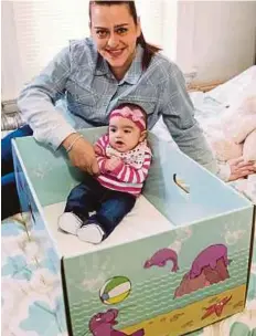  ?? AP
PIC ?? Dolores Peterson and daughter, Ariabella, at their home in Camden, New Jersey. New Jersey became the first US state to send newborn babies home with a box that doubles as a crib.