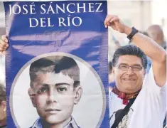 ??  ?? Un hombre levanta un cartel con la imagen de José Sánchez del Río durante la ceremonia de canonizaci­ón en la Plaza de San Pedro, en el Vaticano.