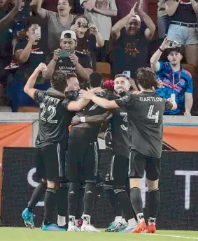  ?? Karen Warren/Staff photograph­er ?? Dynamo midfielder Héctor Herrera and teammates celebrate Amine Bassi’s goal on a penalty kick during the second half Saturday at Shell Energy Stadium. Bassi converted a penalty kick for the second straight game.