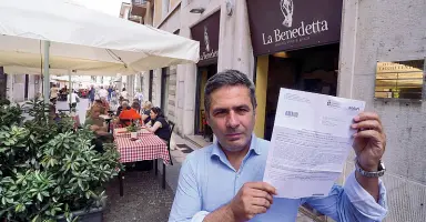  ?? Sartori) (foto ?? In via Stella Patrizio Violante, gestore della pizzeria La Benedetta di via Stella, mostra la multa inflittagl­i per la chiusura anticipata