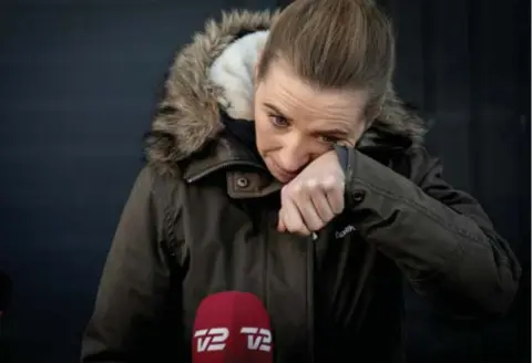  ?? FOTO VIA REUTERS ?? Premier Mette Frederikse­n moest tegen de tranen vechten toen ze een nertsenkwe­kerij bezocht in Kolding.