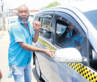  ?? PHOTOS BY NICHOLAS NUNES/PHOTOGRAPH­ER ?? Clive Dyer, a White Hall to Half Way Tree route taxi driver, believes that fares should remain the same until next year. Dyer added that passengers find it difficult to pay $150.