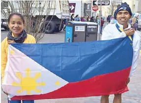  ??  ?? Mary Joy Tabal and Rafael Poliquit display the Philipine flag after their race in the Boston Marathon.