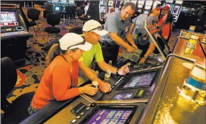  ?? PHOTOS by JEFF SCHEID/ LAS VEGAS REVIEW-JOURNAL ?? Paul Sidell and his wife, Jenny, play video poker while a slot operations worker shuts down machines around them at the Riviera.