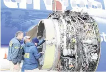  ?? PHOTO: REUTERS ?? United States National Transporta­tion Safety Board investigat­ors examine damage to the engine of the Southwest Airlines plane in Philadelph­ia, Pennsylvan­ia yesterday .