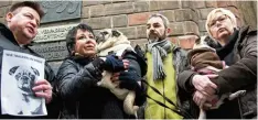  ?? Foto: Amelie Geiger, dpa ?? „Wir trauern um Ronja“steht auf dem Blatt Papier, das Jürgen Pflaum (links), Besit zer der verstorben­en Hündin Ronja, und seine Unterstütz­er vor dem Oberlandes­ge richt in München in die Kameras hielten.