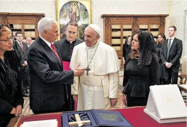 ?? Alessandro Di Meo / Associated Press ?? Pope Francis exchanges gifts with Vice President Mike Pence and his wife, Karen, right. “You made me a hero” back home, Pence told the pope, by granting him a private audience at the Vatican.