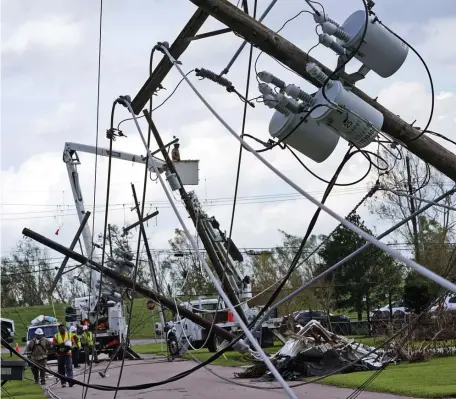  ?? AP ?? WORKING ON IT: Crews begin work on downed power lines leading to a fire station on Aug. 31 in Waggaman, La., as residents try to recover from the effects of Hurricane Ida.