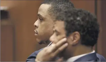  ?? Frederick M. Brown Associated Press ?? ERIC HOLDER JR., left, an aspiring rapper, and his attorney, Aaron Jansen, listen during opening statements in Holder’s trial Wednesday. Rapper Nipsey Hussle was shot 10 times and died a short time later.