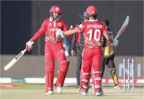  ?? Associated Press ?? Oman’s Aqib Ilyas (left) and team-mate Jatinder Singh celebrate after their team’s victory over Papua New Guinea in Muscat on Sunday.