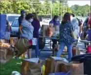  ?? CARLY STONE - MEDIANEWS GROUP ?? Volunteers and Community Action Partnershi­p staff help distribute resources to residents in need.