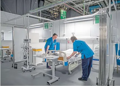  ?? Pictures: PA/Steve MacDougall. ?? Clockwise from above: The NHS Louisa Jordan hospital, built at the SEC Centre in Glasgow in response to the pandemic; healthcare assistant Mike Boyle and Dr Nico Grunenberg, King’s Cross Hospital, Dundee, at Tayside’s new drive-through assessment centre for coronaviru­s; and Dr Lewis Morrison, who says difficult choices will have to be made.