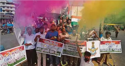  ?? REUTERS PIC ?? People releasing coloured smoke as they celebrate after Indian authoritie­s said their jets conducted air strikes on militant camps in Pakistani territory, in Ahmedabad, India, yesterday.