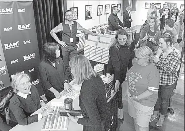  ?? Arkansas Democrat-Gazette/BENJAMIN KRAIN ?? Hillary Clinton signs copies of her books Saturday morning at the Butler Center for Arkansas Studies in Little Rock. People waited in line for up to four hours to get her autograph.