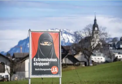  ?? FOTO: URS FLUEELER/TT ?? På affischer inför folkomröst­ningen om maskerings­förbud i Schweiz har en heltäckand­e slöja kopplats samman med extremism.