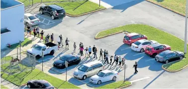  ?? AFP/FEDERICO PARRA ?? Students are evacuated by police from Marjory Stoneman Douglas High School in Parkland, Florida, after a shooter opened fire on the campus.