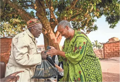  ?? KELLEY FRENCH/USA TODAY ?? Wanda Tucker greets Antonio Manuel Domingos, the village soba, or local governor.