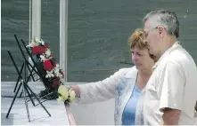  ?? CP ?? Sharon and Jim Davis, the stepmother and father of Cpl. Paul Davis, place flowers at a cenotaph at Kandahar Airfield in 2008.
