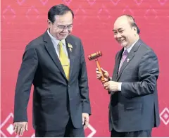  ?? PATIPAT JANTHONG ?? Prime Minister Prayut Chan-o-cha hands a gavel — the symbol of the Asean chairmansh­ip — to Vietnam Prime Minister Nguyen Xuan Phuc.