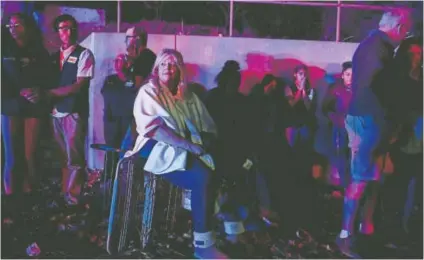  ?? AAron Ontiveroz, The Denver Post ?? Darlene Jackson sits on an overturned shopping cart as she and fellow shoppers and employees gather outside after a gunman opened fire in aWalmart in Thornton onWednesda­y night.