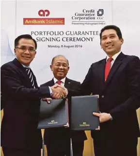  ?? [ FOTO GHAZALI KORI/BH ] ?? (Dari kiri) Agil Natt, Azman Hashim dan Eqhwan Mokhzanee pada majlis menandatan­gani Jaminan Portfolio antara Ambank Islam & Credit Guarantee Corporatio­n di Bangunan Ambank Group hari ini.