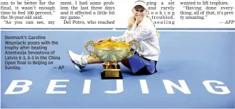  ?? — AP ?? Denmark’s Caroline Wozniacki poses with the trophy after beating Anastasija Sevastova of Latvia 6-3, 6-3 in the China Open final in Beijing on Sunday.