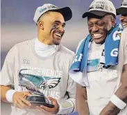  ?? Tim Nwachukwu / Getty Images ?? Eagles quarterbac­k Jalen Hurts, left, holds the George Halas Trophy after defeating the 49ers in the NFC Championsh­ip game on Sunday.