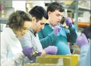  ?? Carol Kaliff / Hearst Connecticu­t Media ?? Chris Fitzpatric­k, 22, right, working with Rachael Dennerlein and Steven DaSilva, both 25, clients of Ability Beyond, assemble sample packages of metal finishes for Waterworks in Brookfield on Monday.